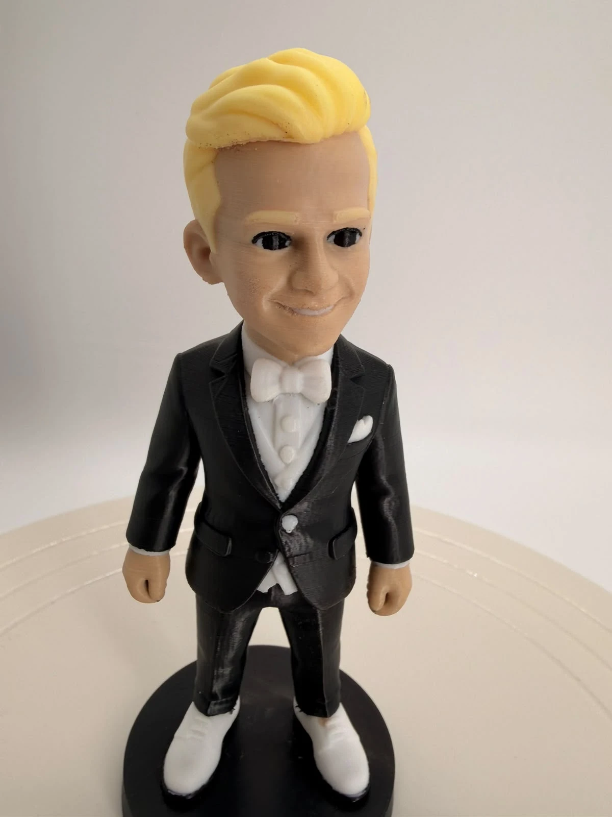 3D-gedruckte Figur eines Mannes mit blonden Haaren im schwarzen Smoking mit weißer Fliege